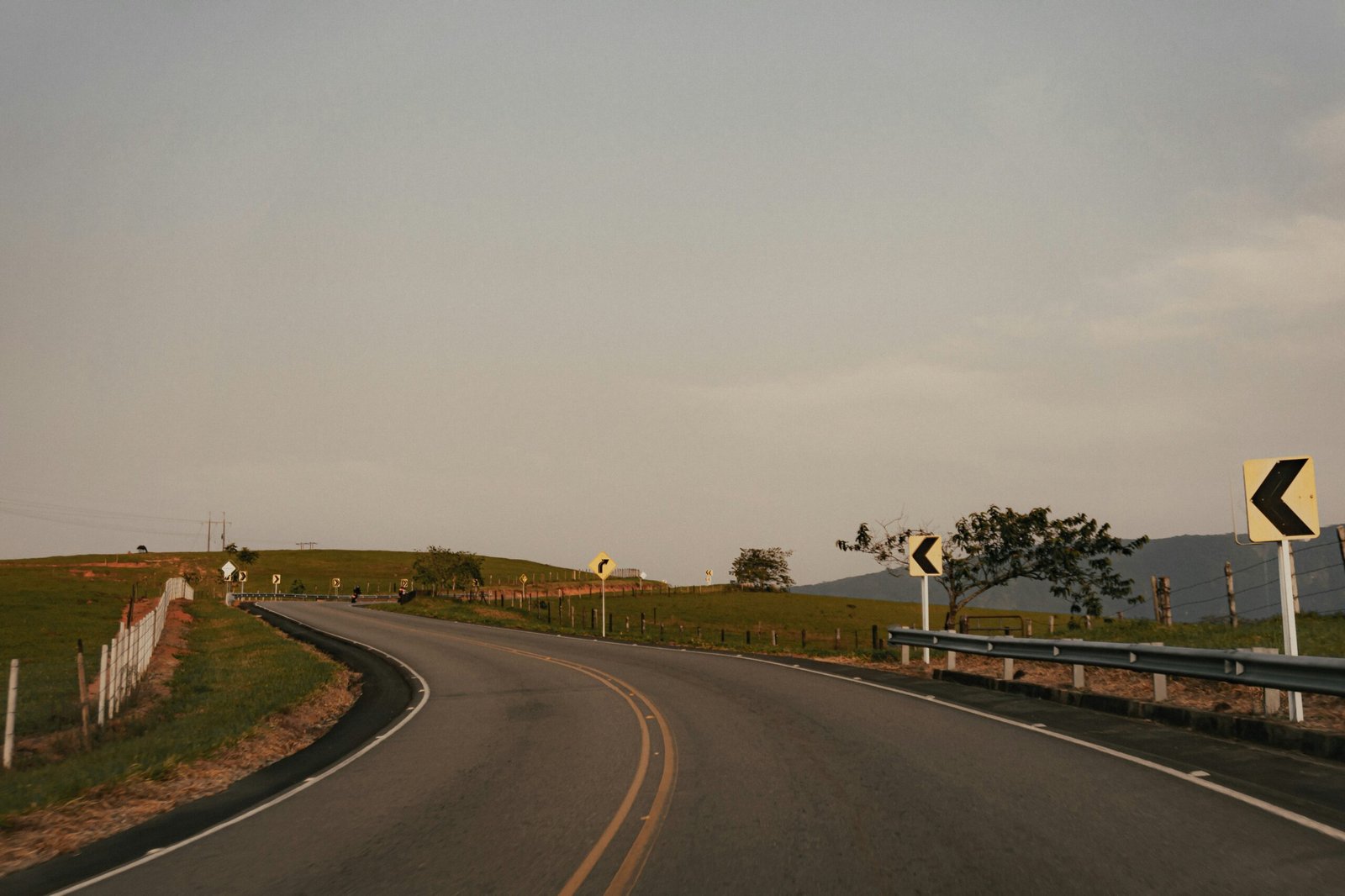 a curved road with a sign on the side of it